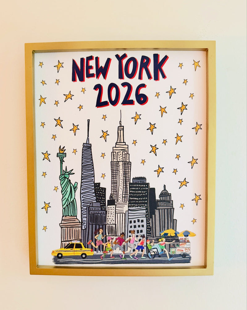 The NYC Skyline print in a gold frame, with runners and yellow taxis along the bottom