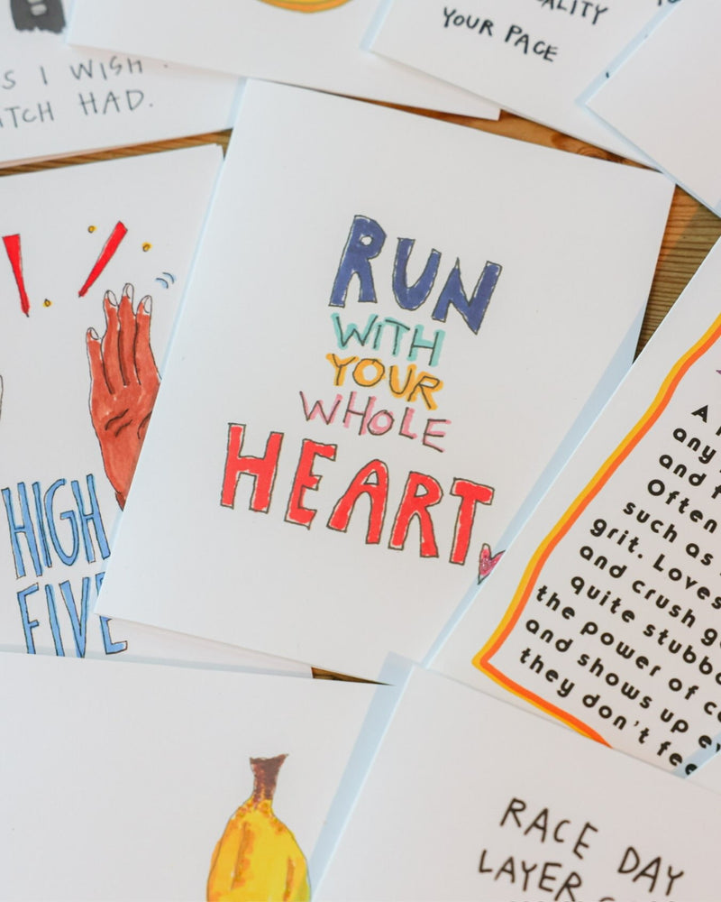 Running greeting cards fanned out on a table, with Run With Your Whole Heart in the middle