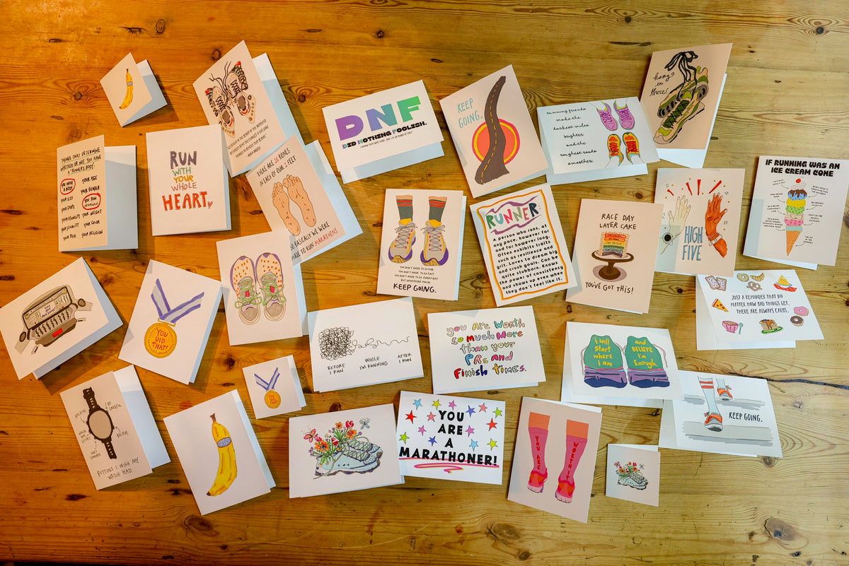 Greeting cards and prints laid out on a wooden floor